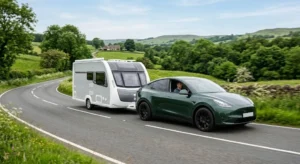 Elektrische auto trekt caravan over landelijke weg met groene omgeving