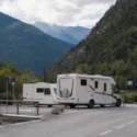 Camper en caravan op officiële kampeerplaats in bergachtige omgeving