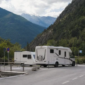 Camper en caravan op officiële kampeerplaats in bergachtige omgeving