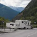 Camper en caravan op officiële kampeerplaats in bergachtige omgeving