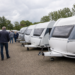 Meerdere caravans staan dicht op elkaar op een Nederlands caravanterrein terwijl bezoekers rondkijken.