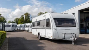 Nieuwe caravans op een dealerterrein bij een werkplaats, passend bij de stijgende verkoop van caravans en de aandacht voor stalling, onderhoud en verzekering.